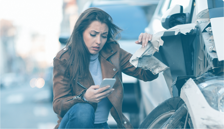 Mujer preocupada después de un accidente de tráfico, mirando su teléfono.